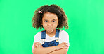 Child, angry and face with arms crossed on green screen with attitude, problem or frustrated in studio. Black kid or girl with mad, grumpy and upset or annoyed facial expression with brat tantrum