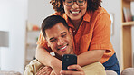 Love, hug diversity, happy couple on sofa with phone, happiness and marriage in apartment. Smile, man and woman embrace on couch in living room, romance and quality time for bonding together in home.