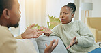 Black couple, argument and talking on sofa in disagreement, conflict or divorce in living room at home. Angry African American man and woman in fight for communication, disagree or arguing on couch