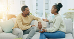 Black couple, argument and talking on sofa in disagreement, conflict or divorce in living room at home. Upset African American man and woman in fight for communication, disagree or arguing on couch