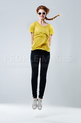 Buy stock photo Girl, sunglasses and casual jump in studio, designer fashion and energy on white background. Female person, clothes and teenager aesthetic for celebration of adolescent youth, luxury shades and style