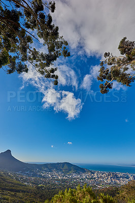 Buy stock photo Beautiful view of a cityscape, nature and Table Mountain in Cape Town, South Africa against a cloudy blue sky with copy space. Landscape of a popular tourist town with greenery during summer