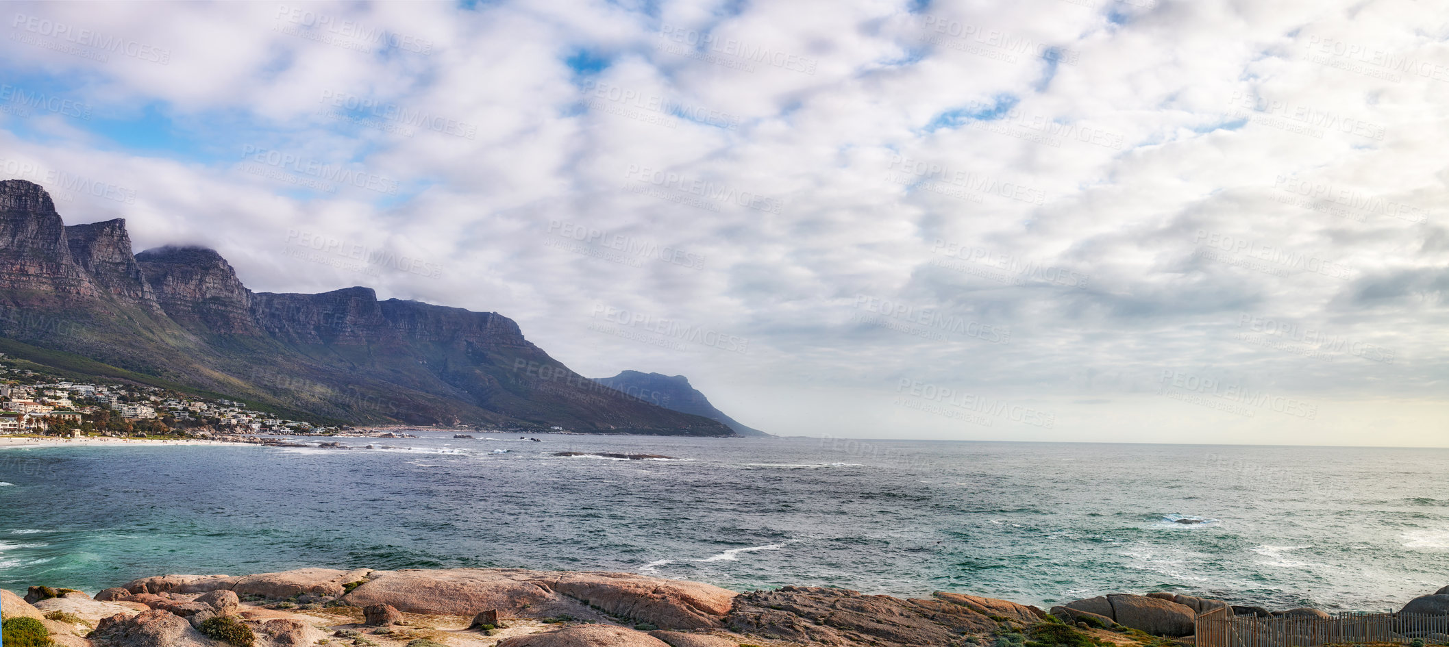 Buy stock photo Beautiful view of the ocean and mountains in Cape Town. Water, waves and rocky planes along the coast. Cloudy sky on top of the beauty of the oceans divine essence of nature in the Western Cape.