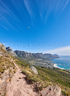 Buy stock photo Famous mountain hiking trail with copy space, rough rocks or stones leading to scenic view of Twelve Apostles in Cape Town. Landscape of ocean, sea and coastal city with blue sky from nature reserve