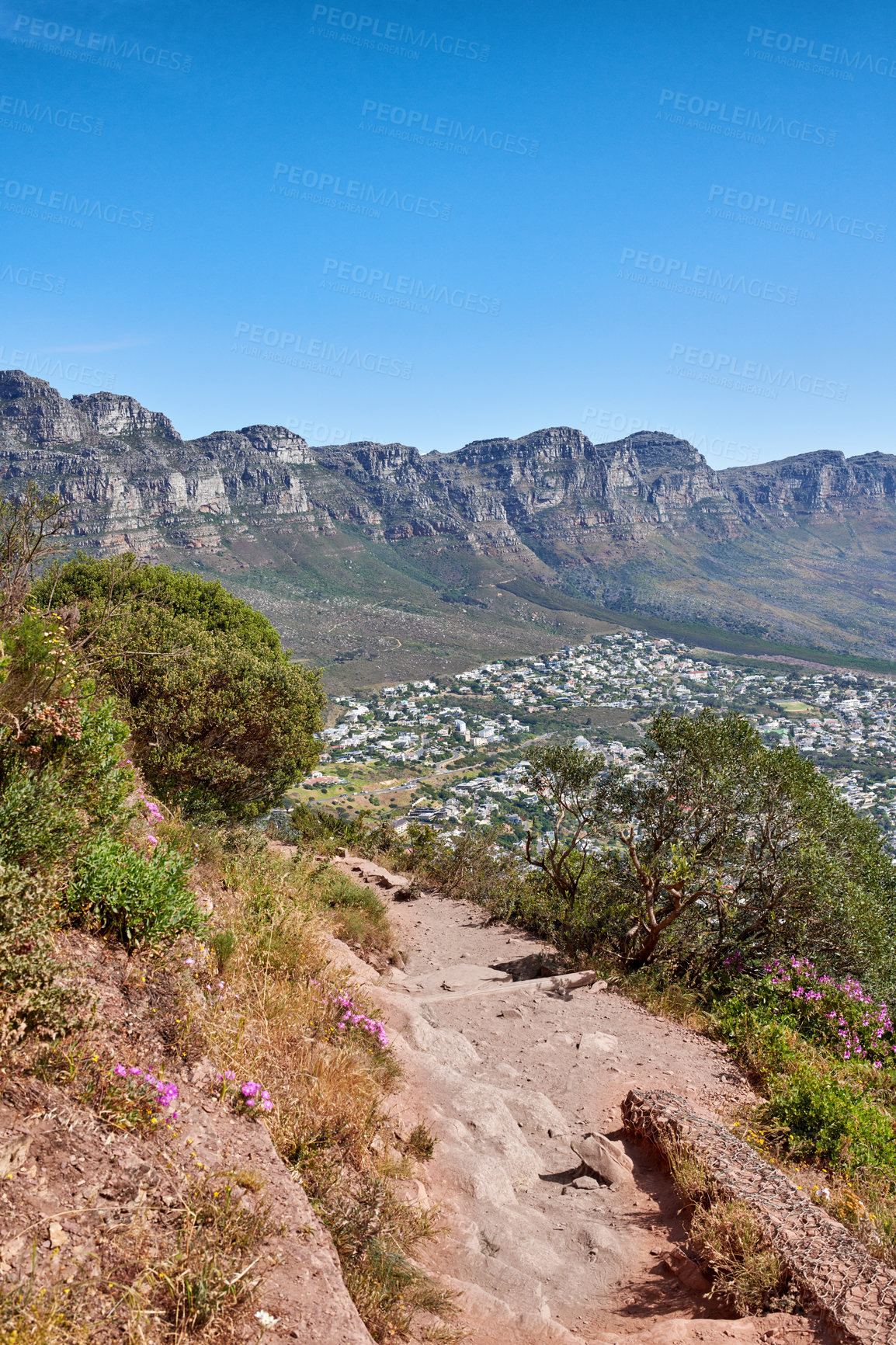 Buy stock photo Secluded mountain trail above a beautiful mountain view and clear blue sky. A mountainous hiking path surrounded by green grass and rocks. Remote destination to explore and enjoy adventure walks