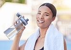 Woman, fitness and water bottle after workout, training and exercise on stadium running track or city sports. Portrait, smile or happy runner with health drink on break, health rest or wellness relax