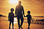 Silhouette, sunset and father holding hands with children at the beach for walking, bonding and vacation. Dark, care and dad with children at the ocean for a walk, travel and quality time together
