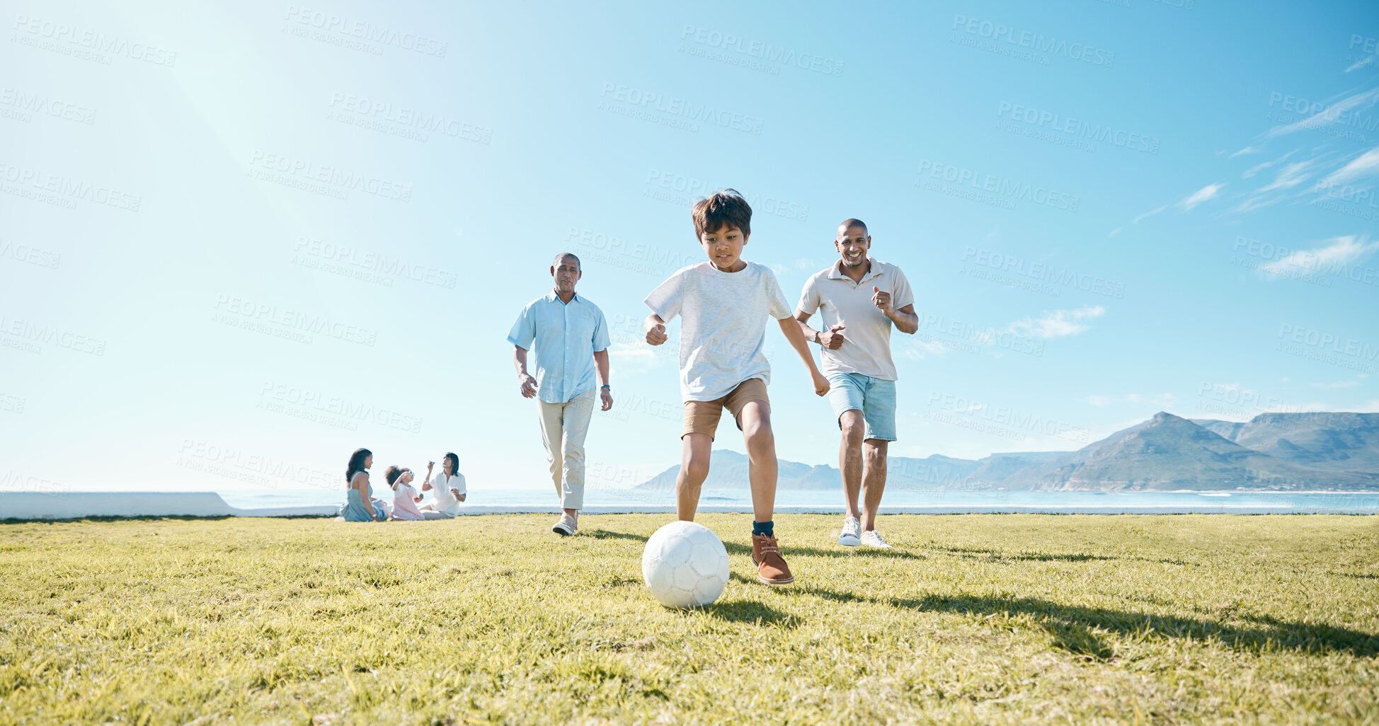 Buy stock photo Family, soccer and men with ball in a park for fun, playing and bonding in nature on blue sky background. Sports, games and boy child with father and grandfather outdoors for weekend football match