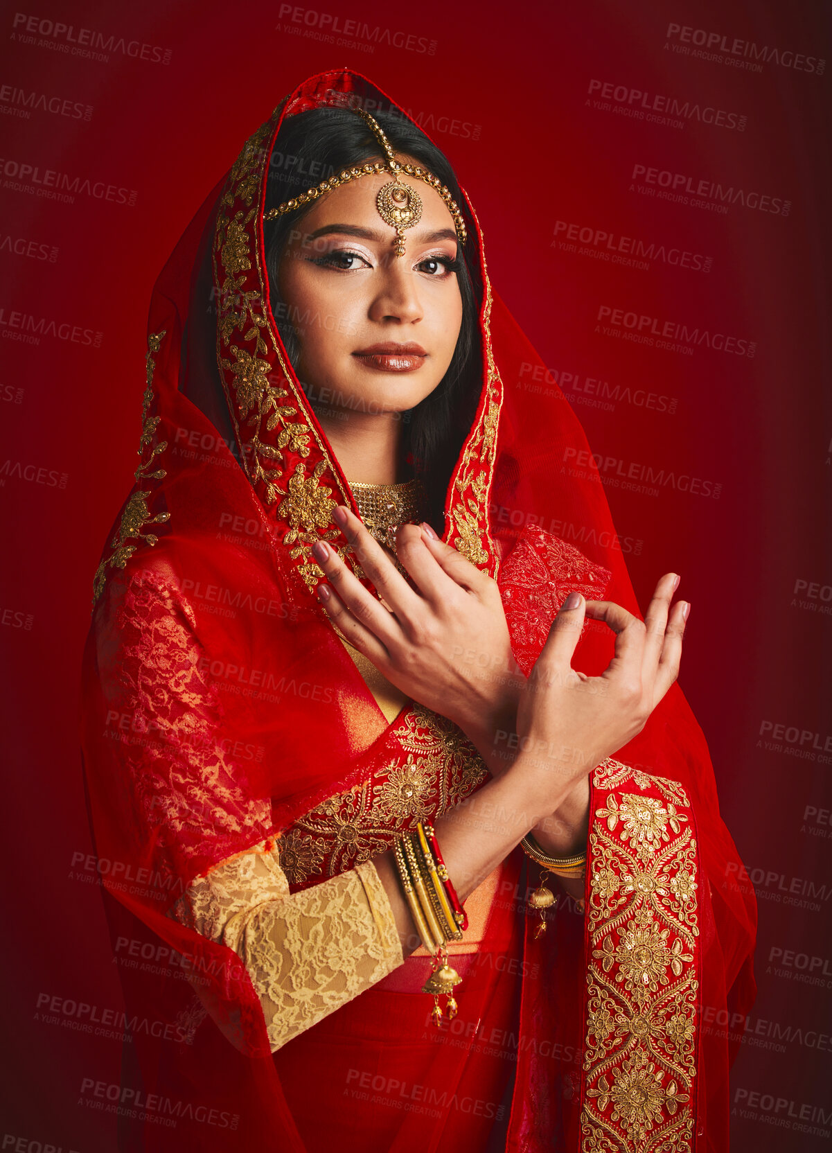 Buy stock photo Fashion, hand sign and portrait of Indian woman with veil in traditional clothes, jewellery and sari. Religion culture, beauty and female person on red background with accessory, cosmetics and makeup