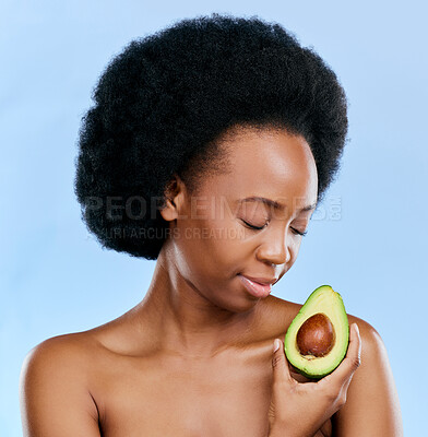 Buy stock photo Face, skincare and avocado with a black woman on a blue background in studio to detox for wellness. Beauty, relax and eyes closed with a natural young female model holding a fruit for antioxidants