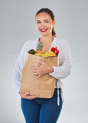 Buy stock photo Portrait, smile and woman with grocery bag, fruit and sales in studio isolated on a white background. Shopping, food and happy customer with organic vegetables for nutrition, healthy diet or wellness