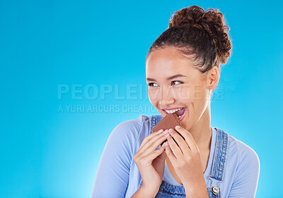Buy stock photo Chocolate, dessert and space with woman in studio for fast food, diet and nutrition. Happy, cacao and sugar with person eating on blue background for candy, health and hungry with mockup