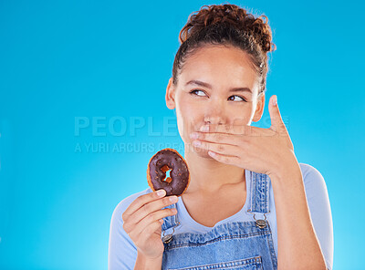 Buy stock photo Chocolate, diet and donut with woman in studio for fast food, dessert and nutrition. Happy, cake and sugar with person eating on blue background for candy, health and hungry with mockup space