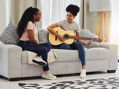 Buy stock photo Guitar, happy or women in house for music, social or entertainment while laughing together on sofa. Smile, acoustic or creative musician friends with an instrument for artistic expression in a home
