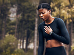 Tired, asthma and black woman athlete with breath problem while running, training or exercise and a chest pain. Cardio, forest and young female person or runner with heart attack risk or injury