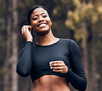 Fitness, black woman listening to podcast and in nature with earphones happy for training. Exercise or workout, training or happy and female athlete listen to radio or music for motivation in forest