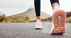 Shoes, athlete and road by a mountain outdoor ready to start a run for health and wellness. Feet, person and running fitness for workout, training and exercise with sport and active in nature