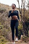 Nature, fitness running and woman for body training and cardio wellness, outdoor challenge or happy hiking. Sports runner, athlete or african person for cardio workout and marathon exercise in forest