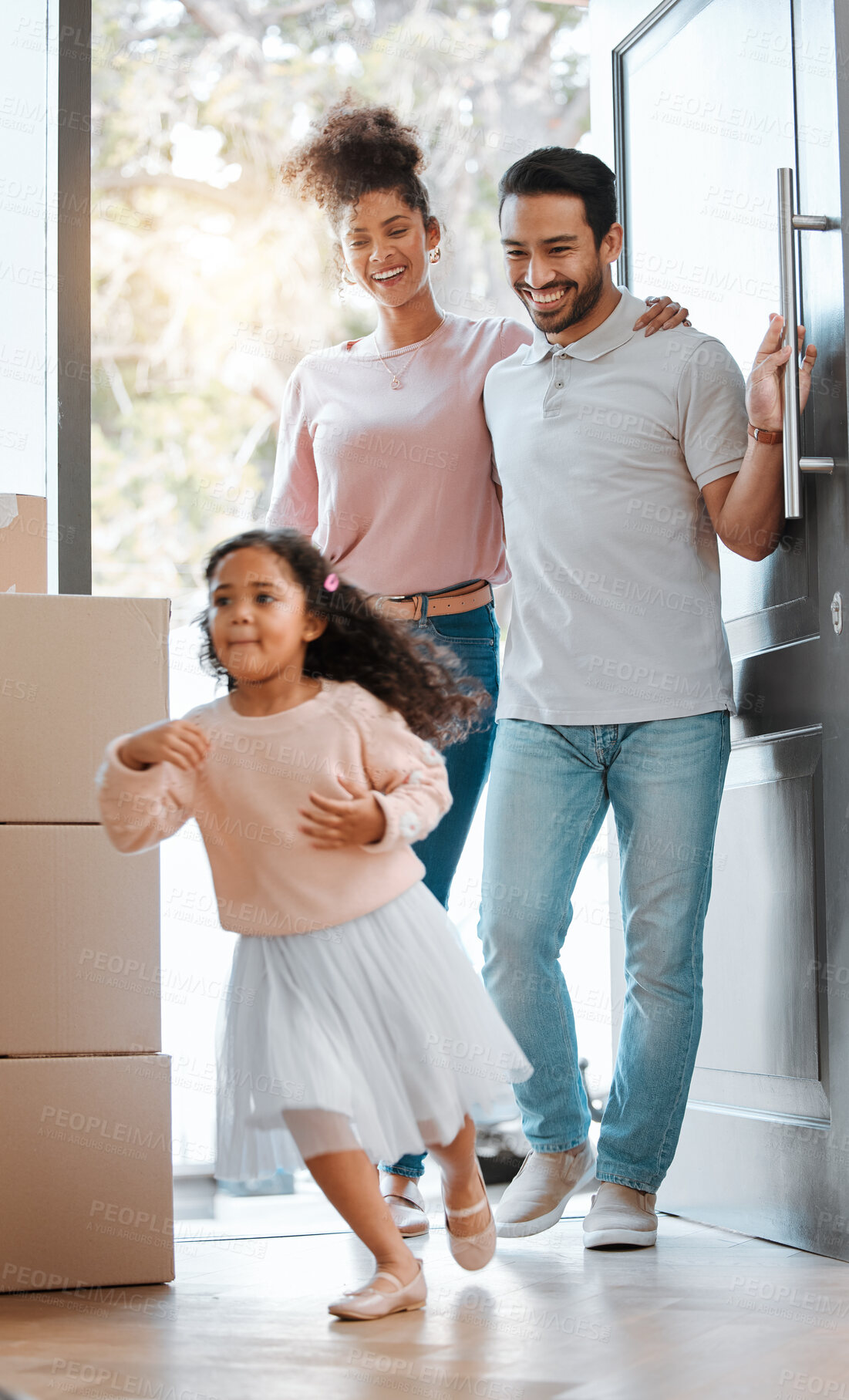 Buy stock photo Happy family, real estate and moving in new home for investment, property or fun relocation by door. Father, mother and daughter smile playing in house for mortgage loan, renovation or beginning