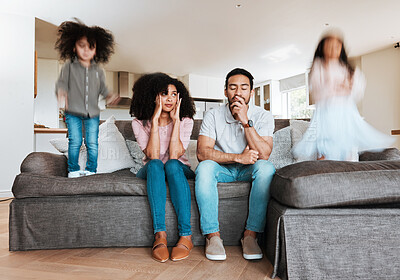 Buy stock photo Children jumping with stressed parents on the sofa to relax in the living room of their house. Upset, burnout and excited kids playing with blur motion on couch with tired exhausted mother and father