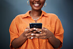 Typing, closeup and hands with a phone on a dark background for communication or social media. Smile, contact and a black woman with a mobile for an app or chat isolated on a studio backdrop for web