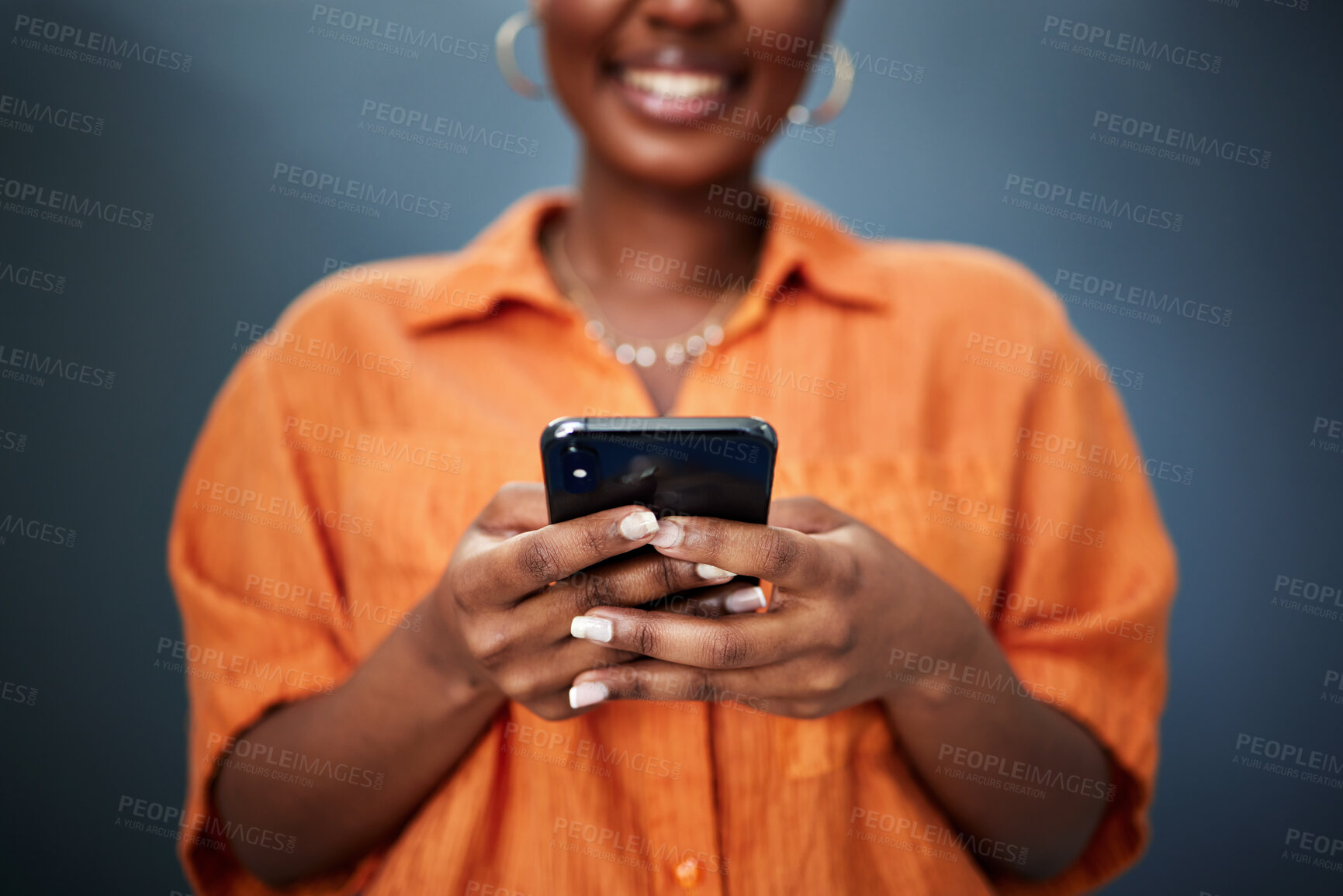 Buy stock photo Typing, closeup and hands with a phone on a dark background for communication or social media. Smile, contact and a black woman with a mobile for an app or chat isolated on a studio backdrop for web