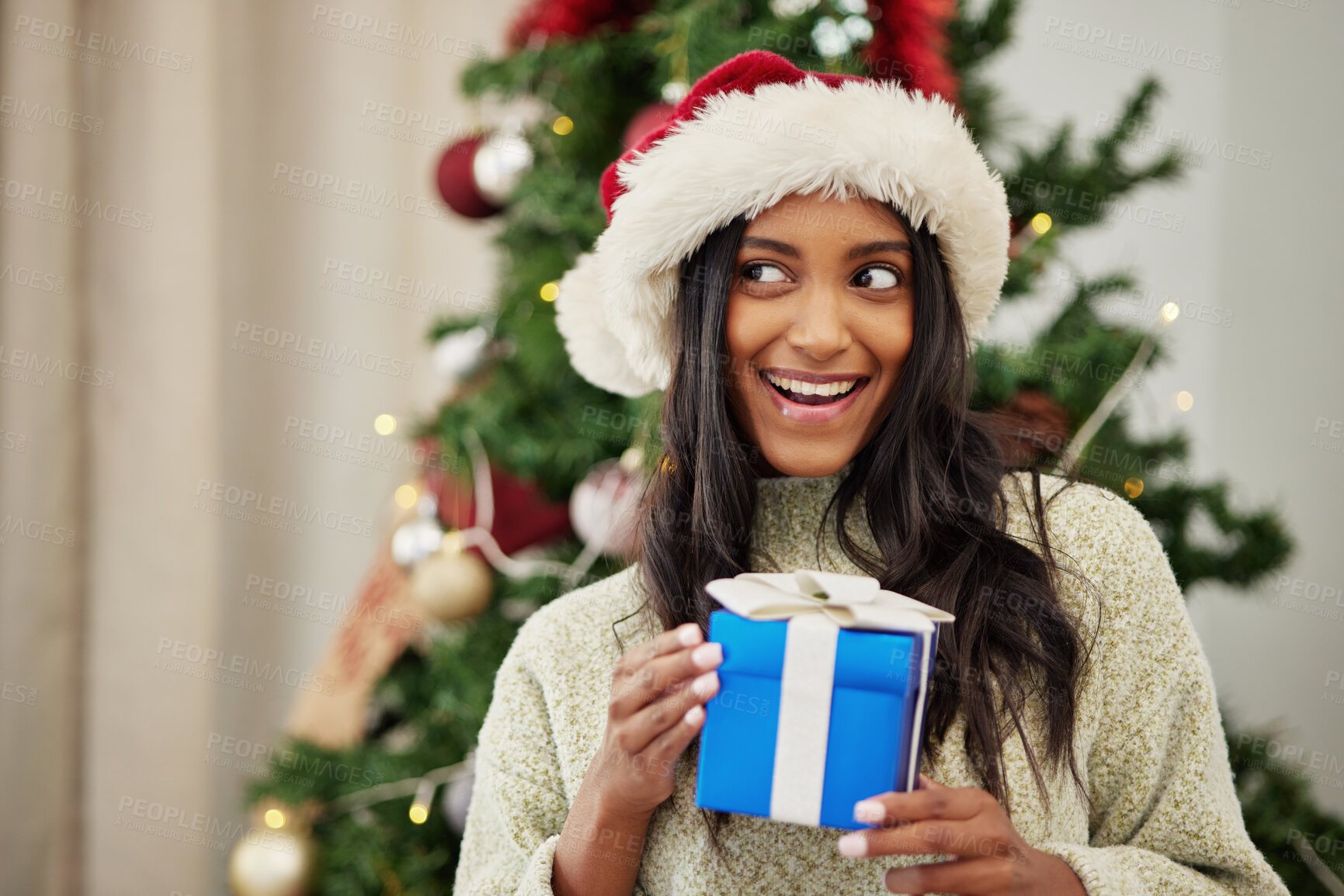 Buy stock photo Christmas, thinking or happy woman with a gift or box in present on a holiday celebration at home. Wonder, smile or excited Indian girl with present with giveaway prize package in a house in winter