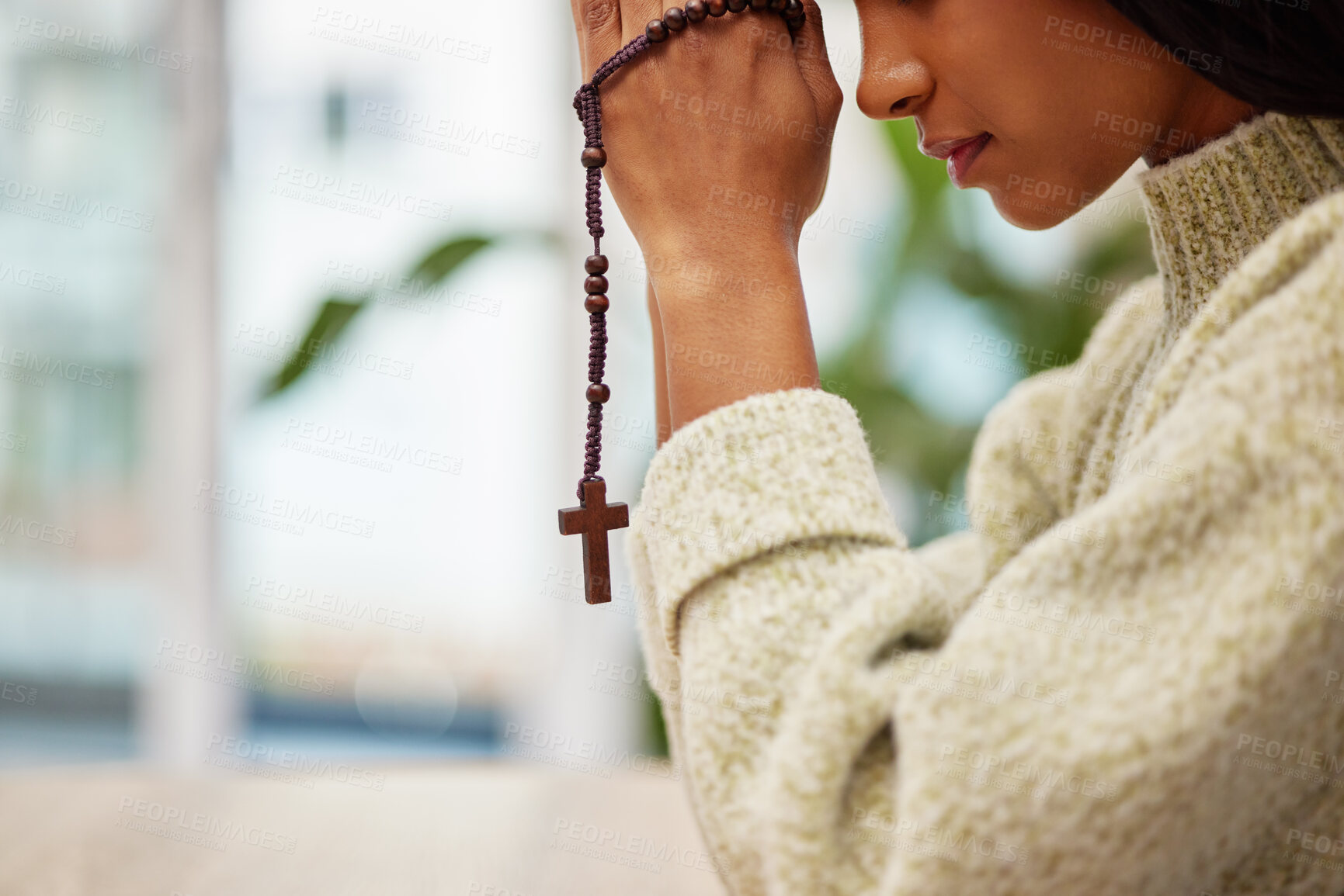 Buy stock photo Hands, rosary and woman praying for help, faith or gratitude to God, praise and humble in her home. Jesus, worship and lady person in prayer with religious cross for hope, trust or Christian guidance