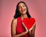 Smile, heart and valentines day with a woman on a pink background in studio for love or romance. Eyes closed, emoji and social media with a happy young female holding a shape or symbol of affection