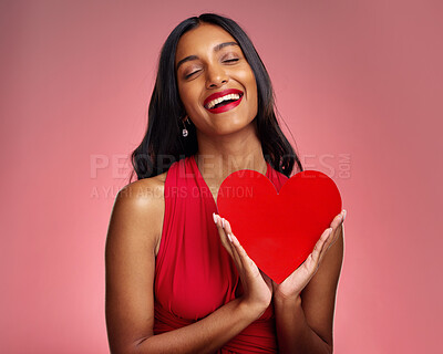 Buy stock photo Smile, heart and valentines day with a woman on a pink background in studio for love or romance. Eyes closed, emoji and social media with a happy young female holding a shape or symbol of affection