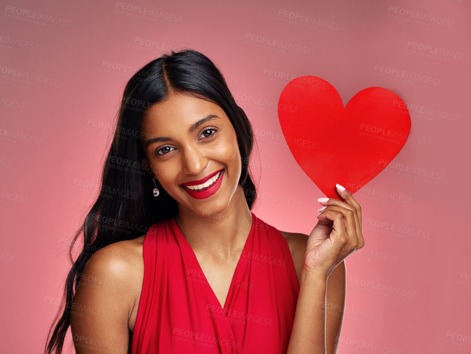 Buy stock photo Portrait, heart and smile with a woman on a pink background in studio for love or romance. Valentines day, emoji and social media with a happy young female holding a shape or symbol of affection