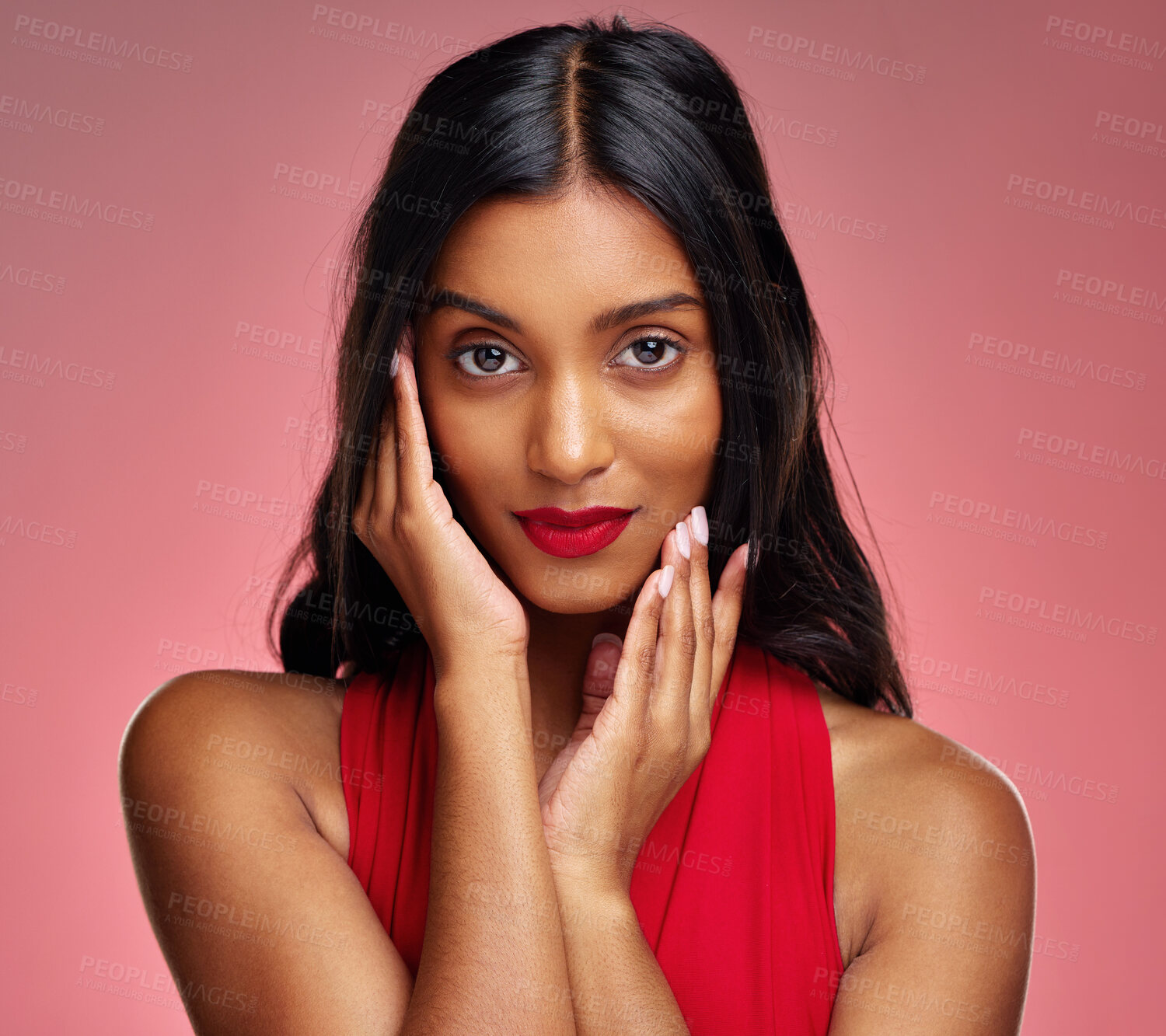 Buy stock photo Woman, red lipstick and beauty, hands touching face with makeup and cosmetics glow on pink background. Cosmetology, Indian female model in portrait and shine with wellness and skincare in studio