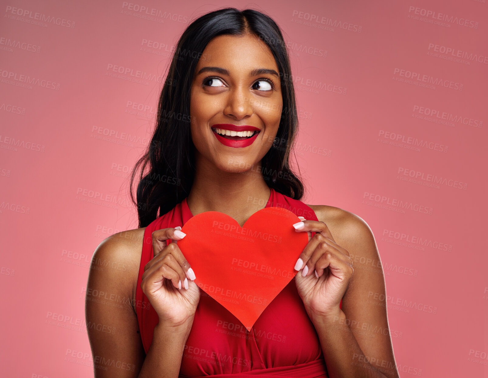 Buy stock photo Thinking, heart and valentines day with a woman on a pink background in studio for love or romance. Idea, red emoji and social media with an excited young female holding a shape or symbol of care