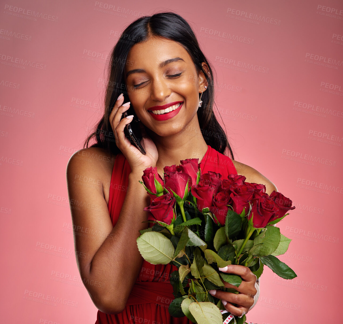 Buy stock photo Phone call, talking and a happy woman with flowers on a studio background for valentines day. Laugh, model and face of a young Indian girl with a rose bouquet and smartphone for romance or love