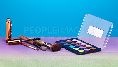 Buy stock photo Makeup, product and palette for color in studio, brush and cosmetics for beauty, mock up and blue background. Powder, mascara and skincare with transformation, change and eyeshadow for aesthetic