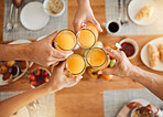 Brunch, hands or people toast with orange juice, beverage or glass drink at lunch, breakfast or food meal. Fruit liquid, top view group or home friends celebrate, support or toasting at reunion event