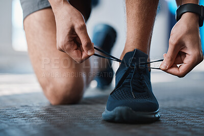 Buy stock photo Fitness, shoes and tie with a sports man in the gym getting ready for a cardio or endurance workout. Exercise, running and preparation with laces of a male athlete or runner at the start of training
