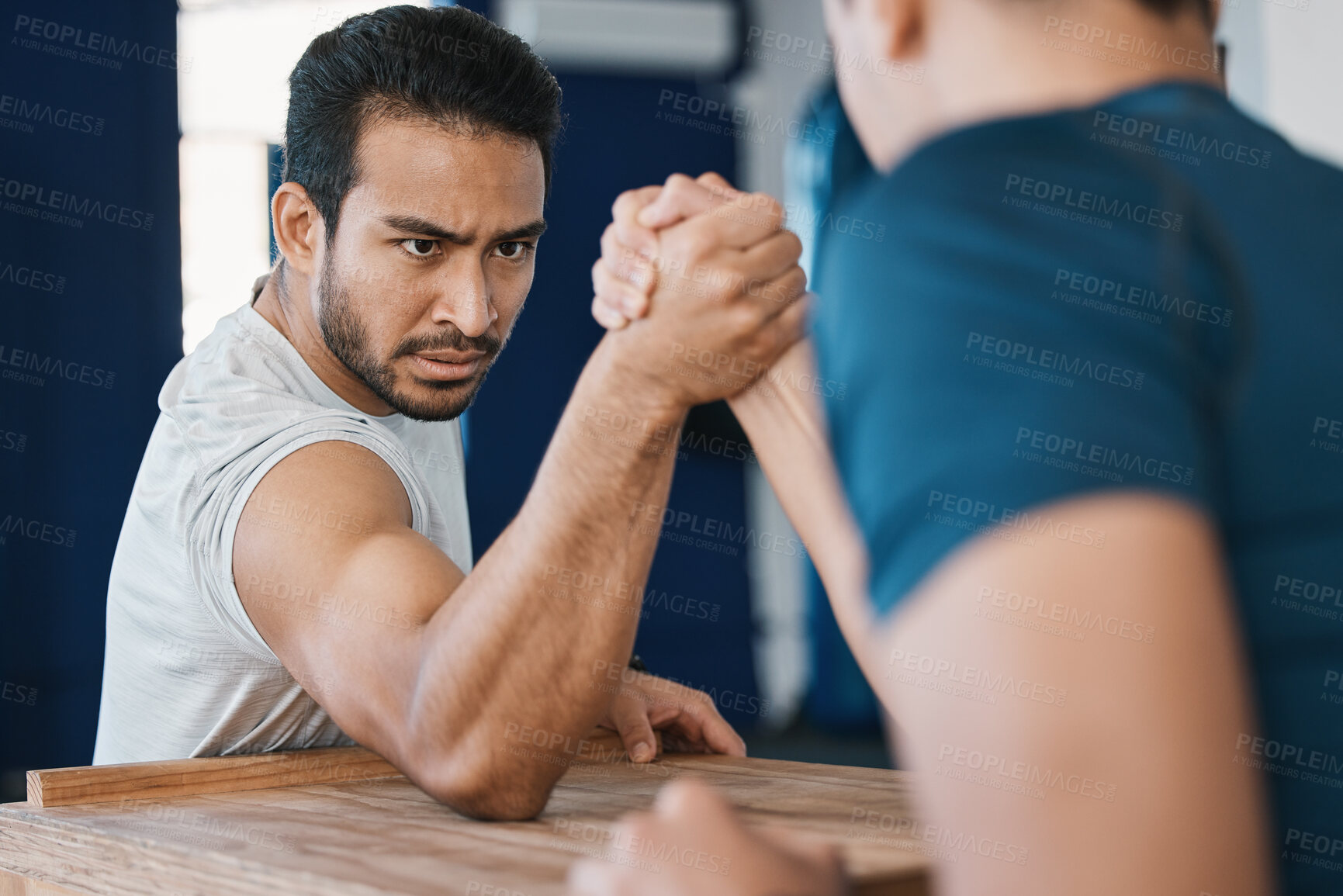Buy stock photo Strength, motivation and male people arm wrestling on a table while being playful for a challenge. Rivalry, game and men athletes doing strength muscles battle for fun, bonding and friendship in gym.