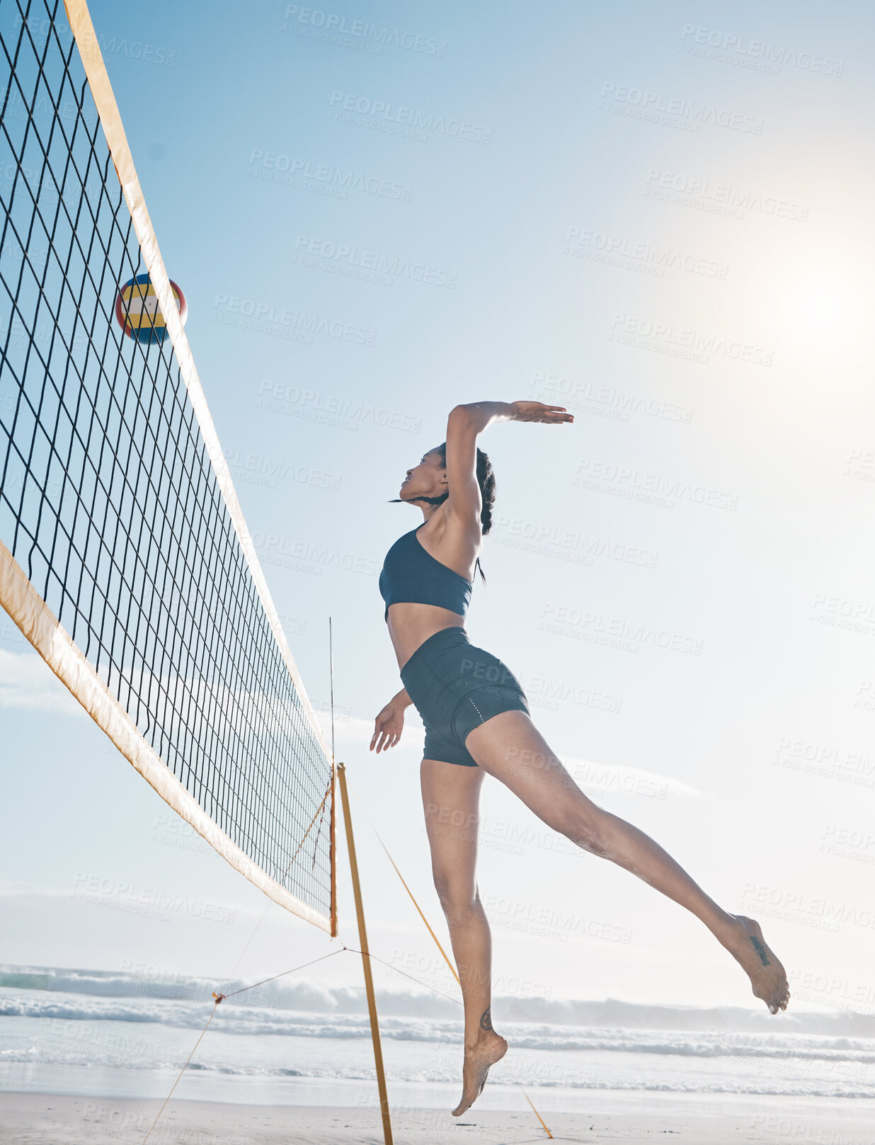 Buy stock photo Woman, jump and volleyball player on beach by net in serious sports match, game or competition. Fit, active and sporty female person jumping or reaching for ball in volley or spike by the ocean coast