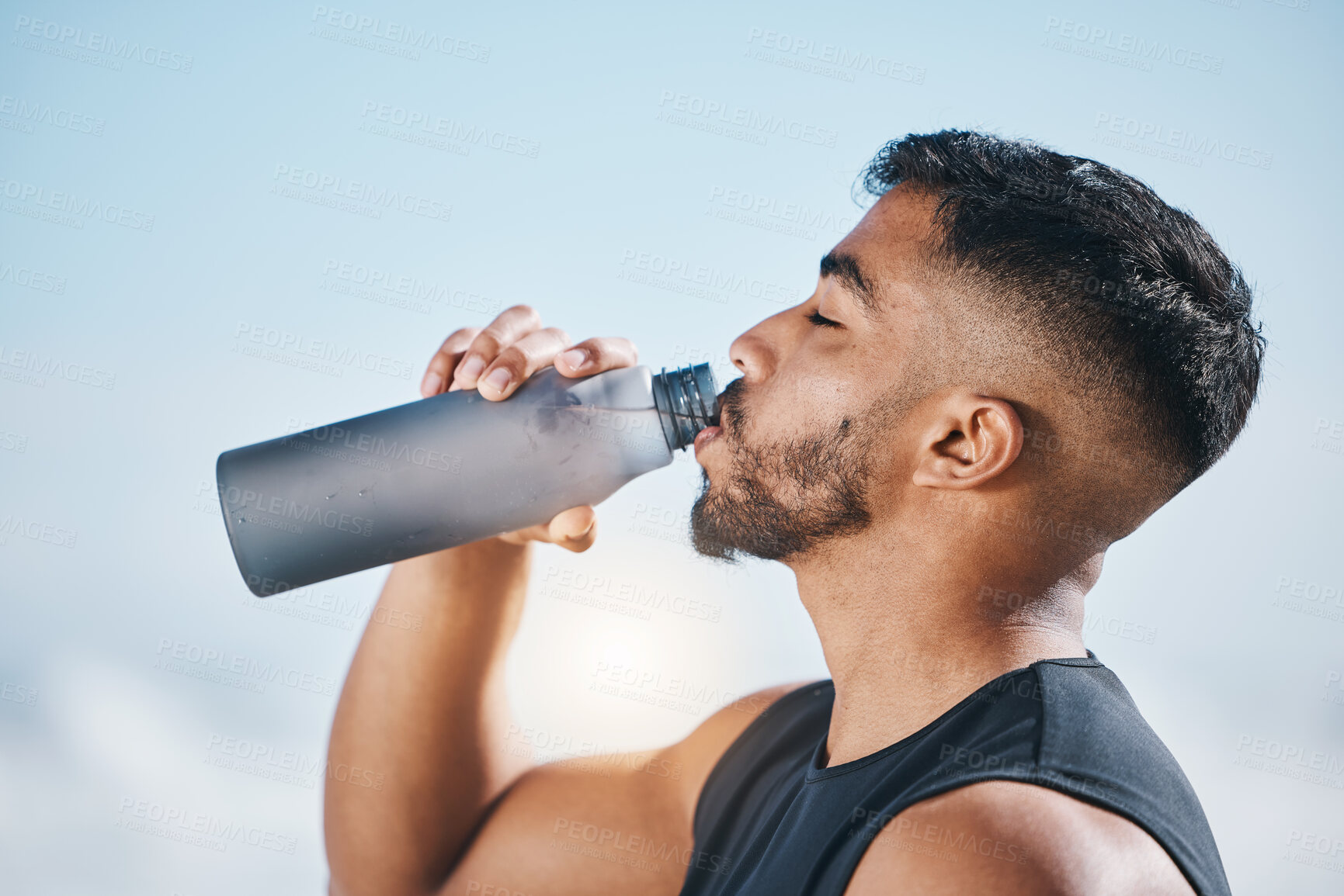 Buy stock photo Fitness, man and drinking water outdoors after training, running or morning cardio routine. Thirst, hydration and Indian male runner with bottle drink after sports, workout and body performance