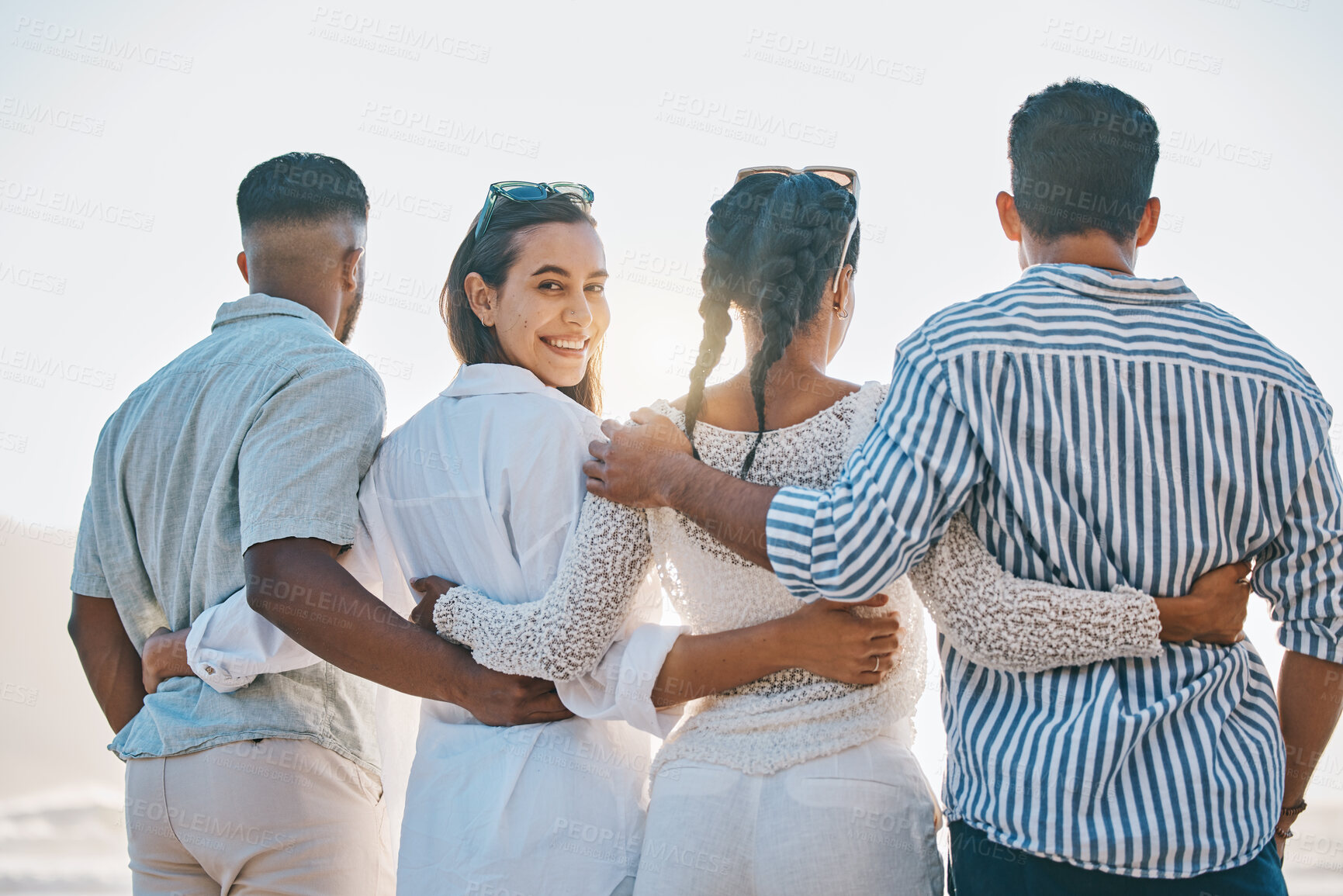 Buy stock photo Happy friends, back and hug on beach for holiday, vacation or weekend together in nature. Rear view of group or people standing and bonding in community, support or trust by the ocean coast outside