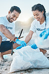 Volunteer, man and woman cleaning beach for world earth day, care and kindness for nature and environment. Help, recycling and happy people at ngo collect plastic waste and pollution from ocean sand.