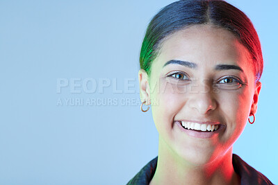 Buy stock photo Portrait, smile and mockup with a woman on a blue background in studio for a logo or branding. Happy, space for marketing or advertising and neon lighting on the face of a female brand ambassador