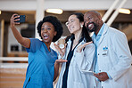 Diversity, happy and group selfie of doctors, surgeon or emergency care workforce in hospital, clinic or medical facility. Asian woman, black woman nurse and African man smile for healthcare photo