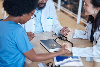 Buy stock photo Hands, bible and a medical team praying during a meeting in a hospital office together. Medical, trust or teamwork with doctors and nurses asking God or Jesus for miracle help in a health clinic
