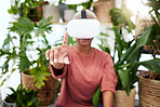 Woman, virtual reality and headset with a finger  at home for metaverse, 3d world or future. Female person with plants and vr glasses for ecology, ai or hand for interaction, video game or experience