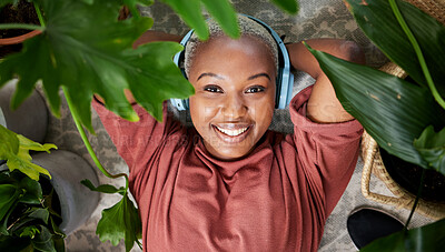 Buy stock photo Headphones, portrait and woman listening to music to relax with plants for peace and calm. Face of a happy black female person streaming sound, audio and podcast or radio online with a smile at home