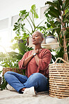 Wellness, peace and woman breathing by plants for meditation in a natural greenhouse. Breathe, gratitude and young calm African female person with a relaxing zen mindset by an indoor nursery garden.