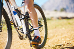 Closeup, outdoor and biker with fitness, cycling and training for a competition, road and sneakers. Zoom, male person or cyclist with workout goal, nature or travel with performance athlete or sports