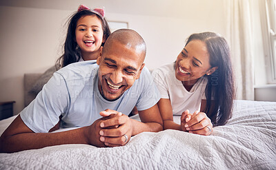 Buy stock photo Family, relax and happy on a bed at home while laughing and playing for funny quality time. Man, woman or parents and a girl kid together in the bedroom for morning bonding with love and care